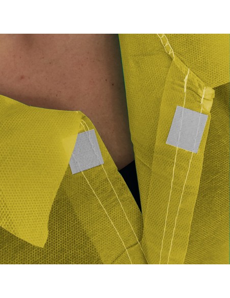 Detalle de velcro en bata en TNT de Polipropileno cierre frontal con velcro color amarillo Detalle de velcro en bata en TNT de Polipropileno cierre frontal con velcro color amarillo