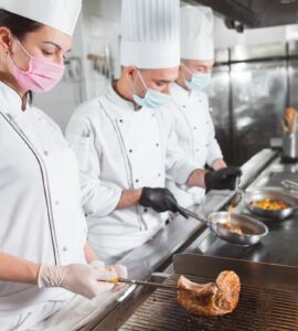Personal de cocica cumpliendo normas de higiene y protección en hospitales